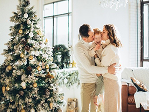 Man, vrouw en kind bij een opgetuigde kerstboom